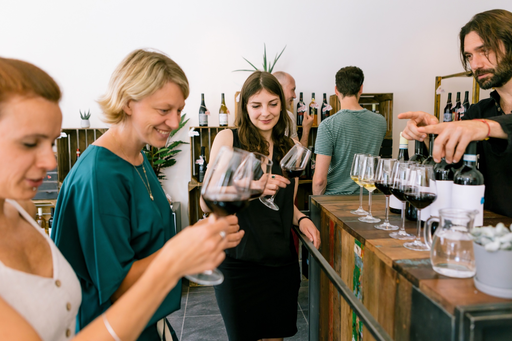 women participating in a blind wine tasting in a winery checking wine color in glass